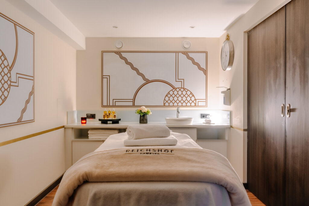 Treatment Room at Reicshof Hotel with a massage bed and spa products