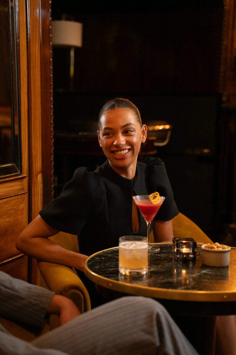 Frau genießt einen Cocktail in der Bar 1910